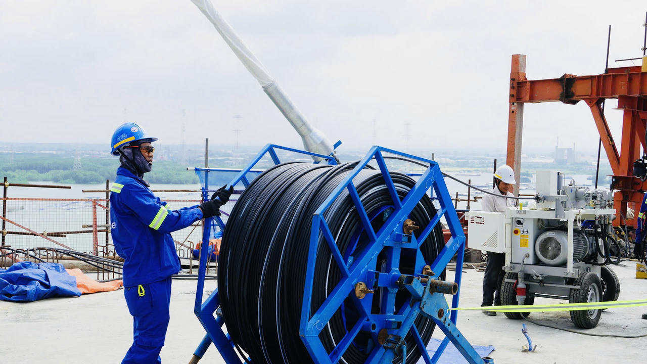 Công nhân, kỹ sư thi công căng bó cáp dây văng đầu tiên tại dự án cầu Phước An.
