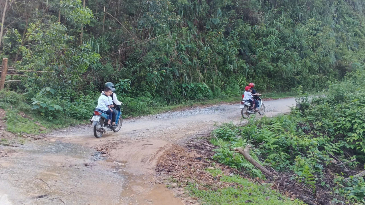 Để vào được điểm trường này, từ Trung tâm xã phải đi theo con đường rừng độc đạo dài hơn 20km gập ghềnh sỏi đá, ngoằn ngoèo với nhiều đèo dốc. Ngay từ sáng sớm, giữa bao la núi rừng, học sinh ăn mặc tươm tất, tay cầm lá cờ đỏ sao vàng được bố mẹ chở tới trường.