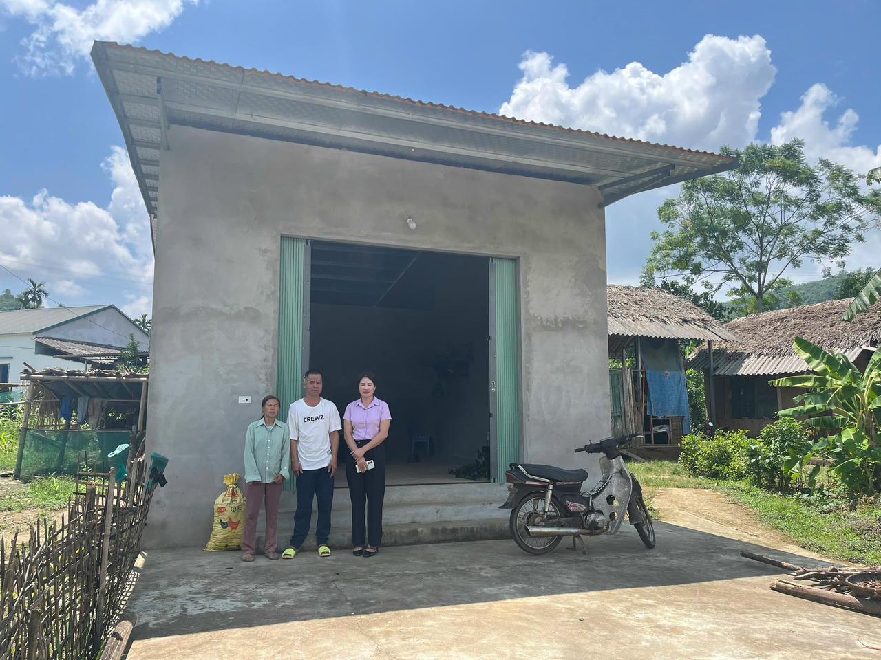 Gia đình anh Hà Văn Giang chụp ảnh cùng bà Đinh Thị Quyết, Phó Chủ tịch HĐND xã Tân Sơn - Phú Thọ bên ngôi nhà mới được hỗ trợ. Ảnh: Kế Nguyễn