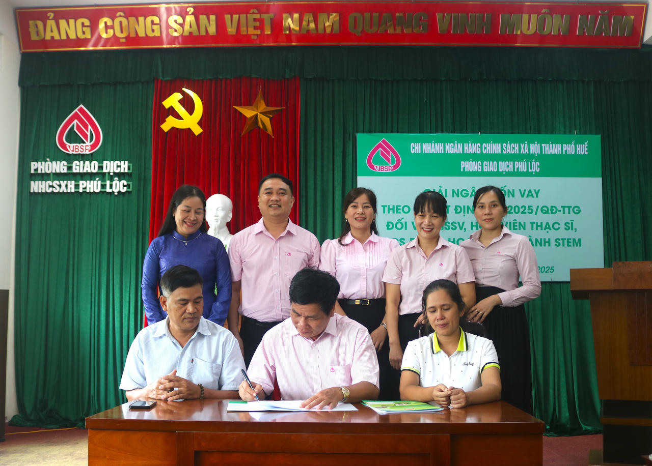 Lãnh đạo Phòng giao dịch Phú Lộc và các khách hàng thực hiện việc ký kết hợp đồng vay vốn.