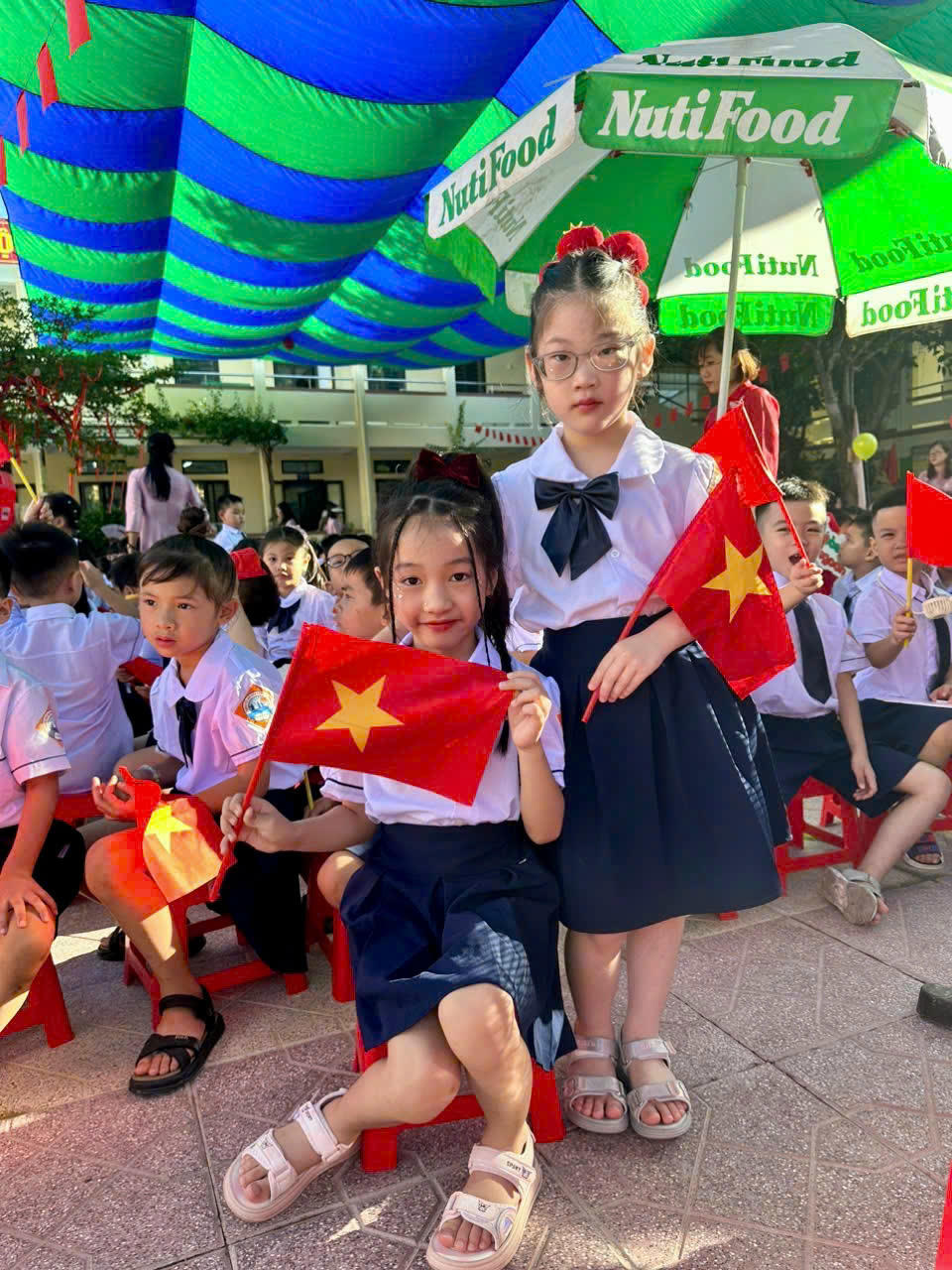 Em Lương Tuệ Mẫn (bên phải) tham dự lễ khai giảng lớp 1.