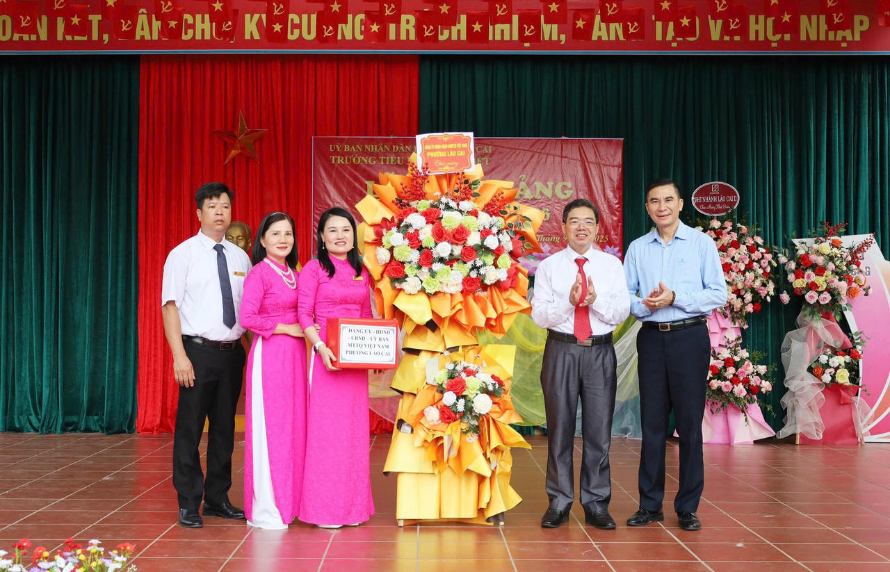 Ông Trần Văn Thiện, Phó Bí thư Thường trực Đảng ủy phường Lào Cai tặng hoa chúc mừng