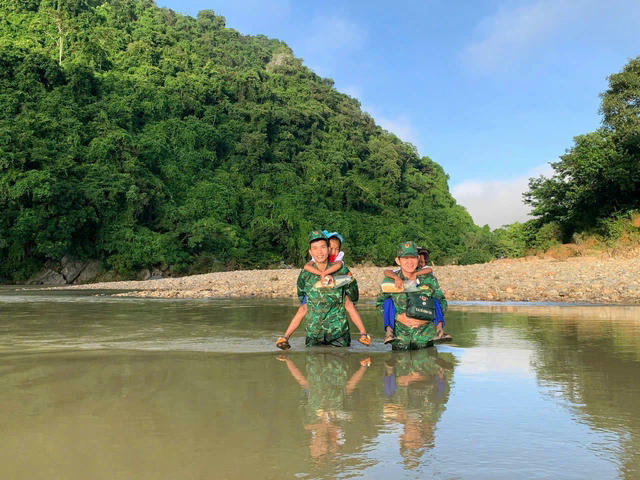 Lực lượng Biên phòng Đồn Biên phòng Hướng Lập cõng học sinh vùng biên đến trường dự khai giảng năm học mới.