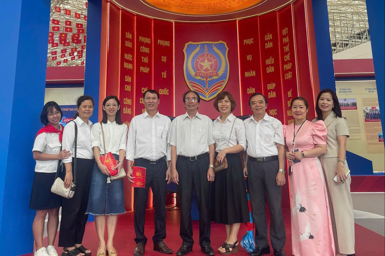 Các giảng viên trường Đại học Luật Hà Nội chụp ảnh lưu niệm tại không gian trưng bày của Bộ Tư pháp.