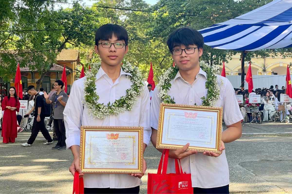 Em Nguyễn Việt Hưng (tay phải) và em Vũ Đức Đam (tay trái) quay trở lại trường trong dịp lễ khai giảng năm học 2025 - 2026 Ảnh: Thanh Bình