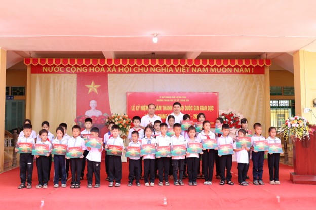 Ông Đinh Tiến Hải và ông Hồng Quang trao học bổng cho các em học sinh Trường Tiểu học Tân Trào và Trường Tiểu học Tôn Đức Thắng tại Tuyên Quang.