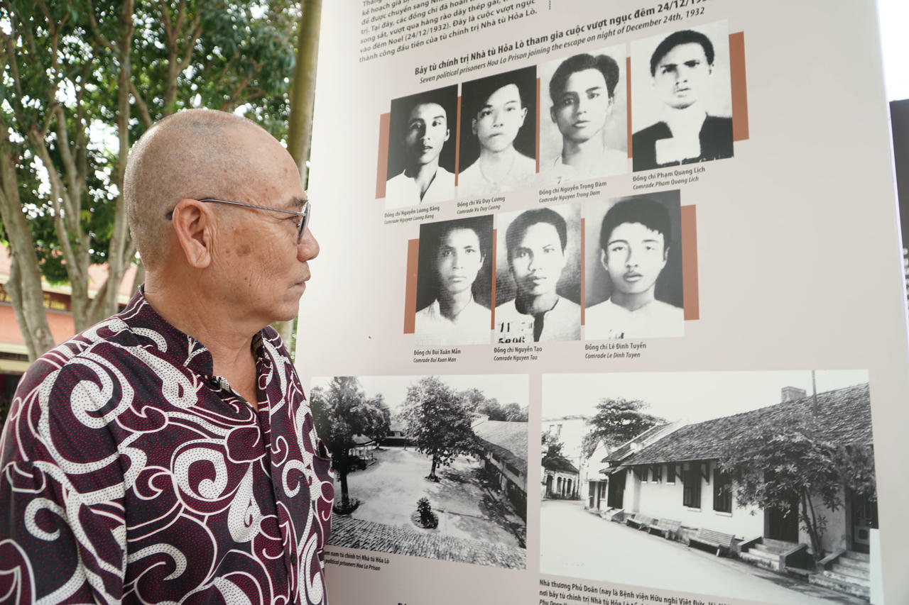 Ông Nguyễn Trung Quốc bên hình ảnh người cha là nhà cách mạng Nguyễn Tạo - người đã thực hiện 2 cuộc vượt ngục lừng danh. Ảnh: Tuyết Lan