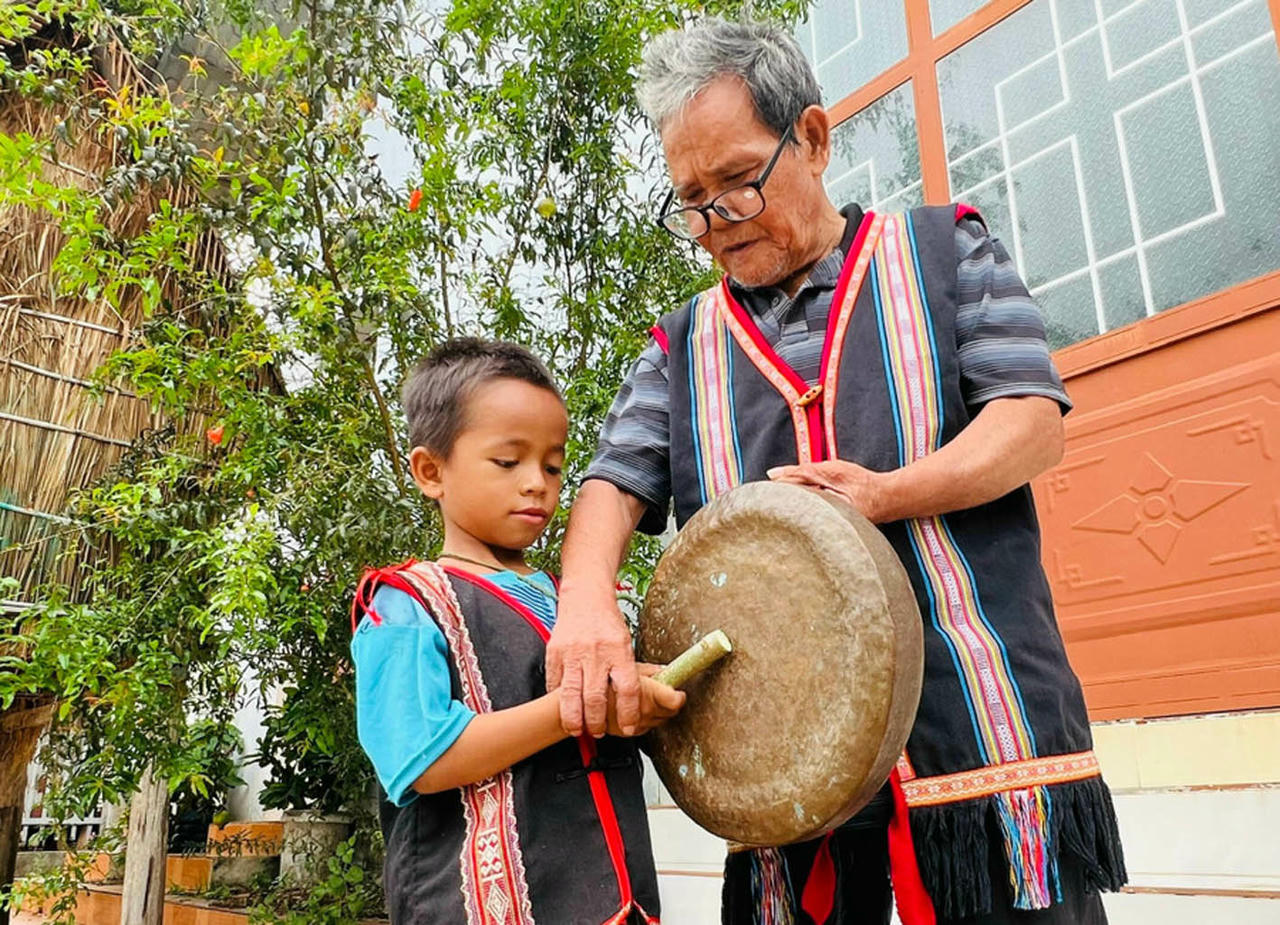 Hình ảnh già làng Siu Klah đang hướng dẫn một thành viên “nhí” trong CLB cồng chiềng làng Dek. (Nguồn: Báo Gia Lai)