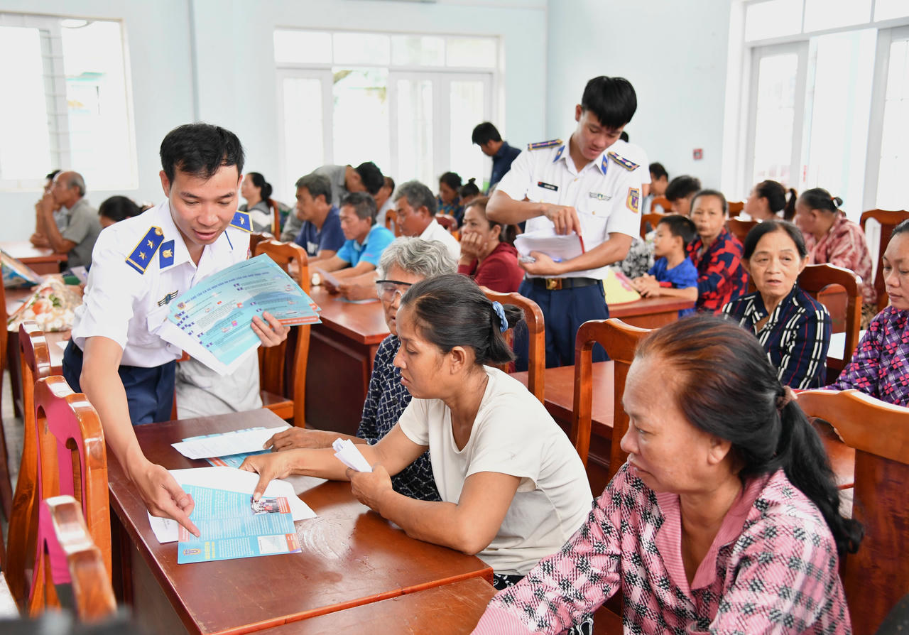 Phát tờ rơi tuyên truyền cho ngư dân.