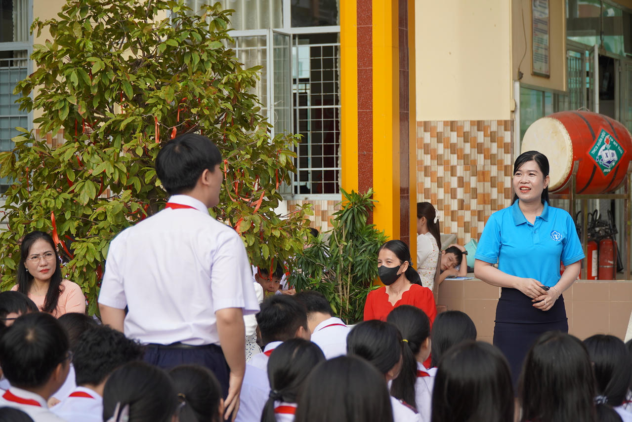 Bà Trần Thị Hồng Loan – Viên chức Phòng Tuyên truyền và Hỗ trợ người tham gia đã thông tin về BHYT đến thầy cô và các em học sinh. Ảnh: Kim Ngân