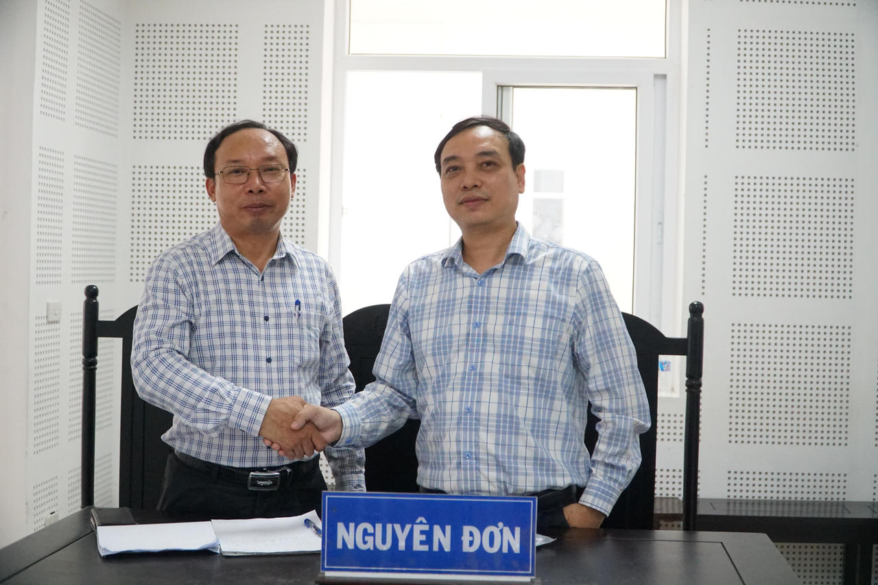 Người bị kiện - ông Võ Duy Trí (bên trái) và người khởi kiện - ông Hoàng Sỹ Đức bắt tay tại toà. (Ảnh: Tuyết Lan)