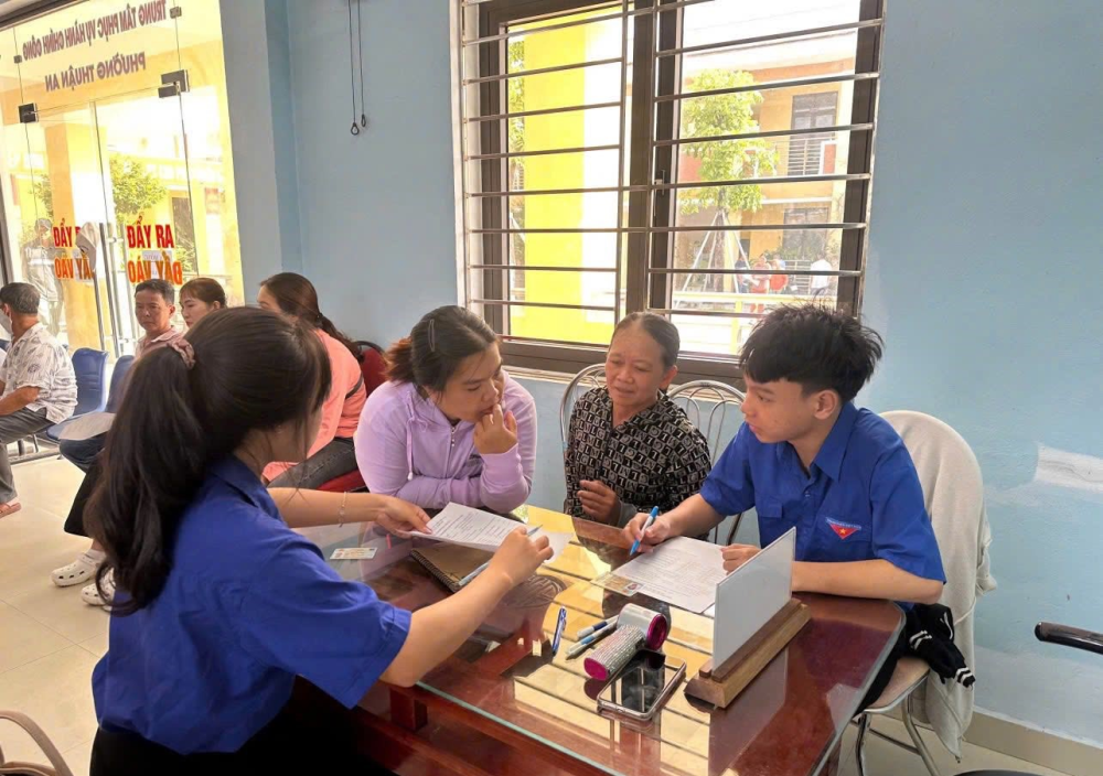 Lực lượng đoàn viên thanh niên hỗ trợ người dân làm thủ tục hành chính.