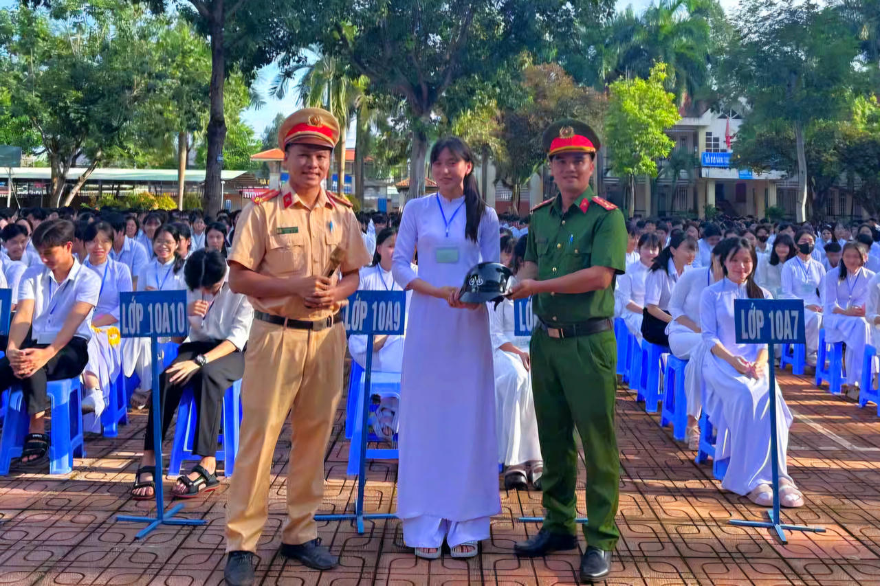 Lực lượng công an trao tặng mũ bảo hiểm, phát tờ rơi và treo pano, áp phích trực quan tại khuôn viên trường.