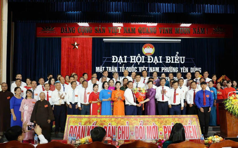 Bà Nguyễn Thị Hà cùng các đại biểu tặng hoa chúc mừng các Ủy viên Ủy ban MTTQ phường Yên Dũng.