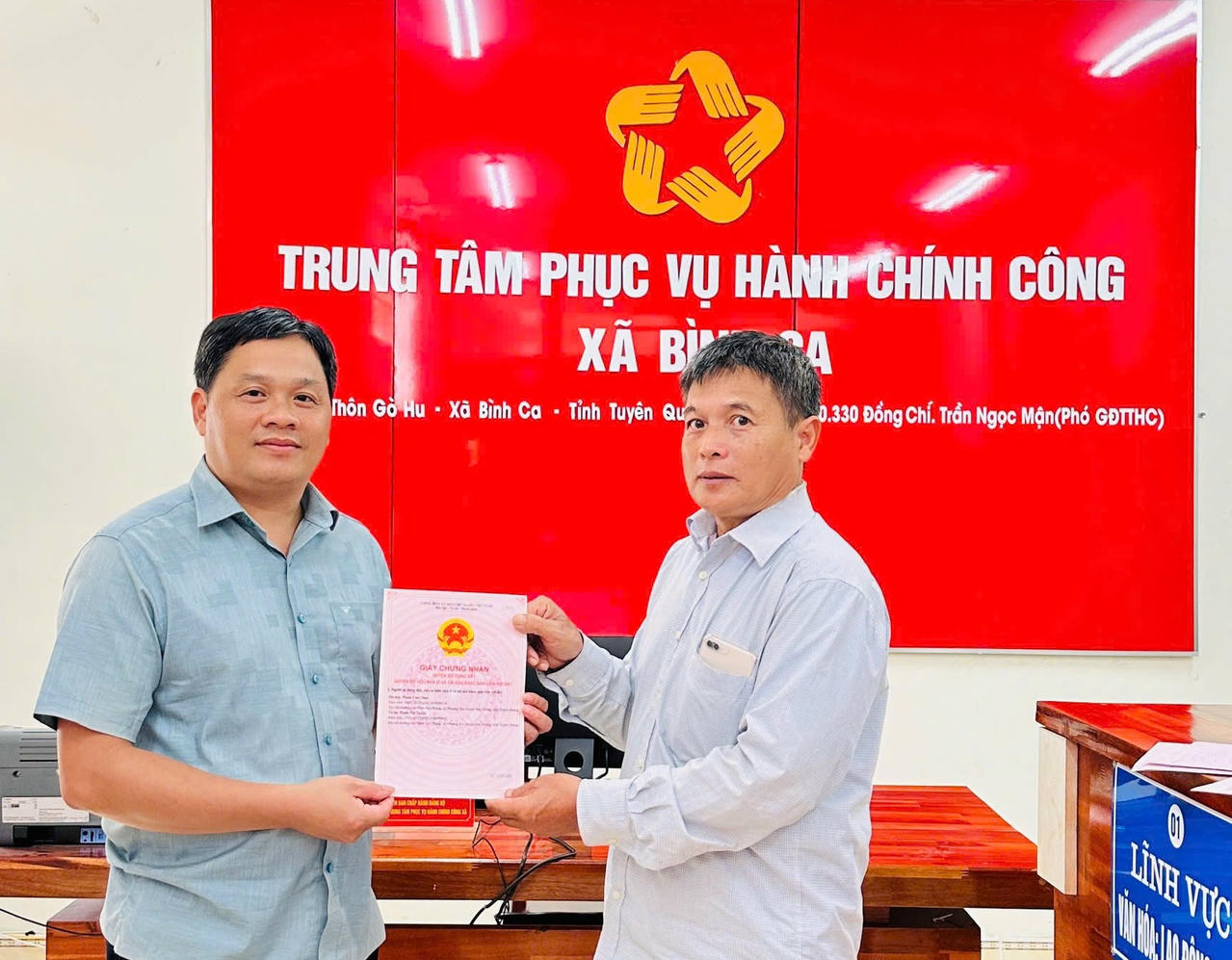 Cán bộ tại Trung tâm hành chính công xã Bình Ca trao Giấy chứng nhận quyền sử dụng đất cho người dân (Ảnh: Lê Hanh)