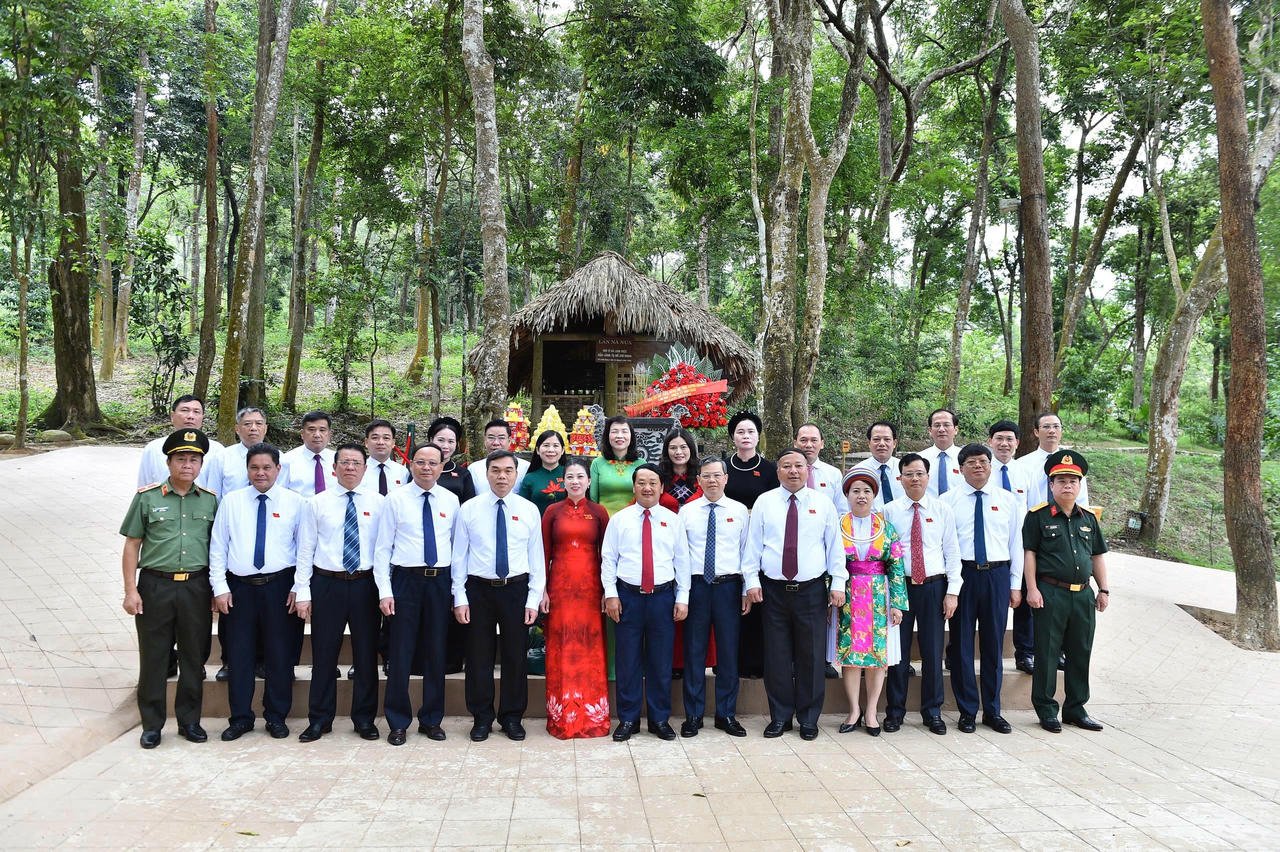 Các đại biểu chụp anh lưu niệm tại lán Nà Nưa. (Ảnh: Lê Hanh)