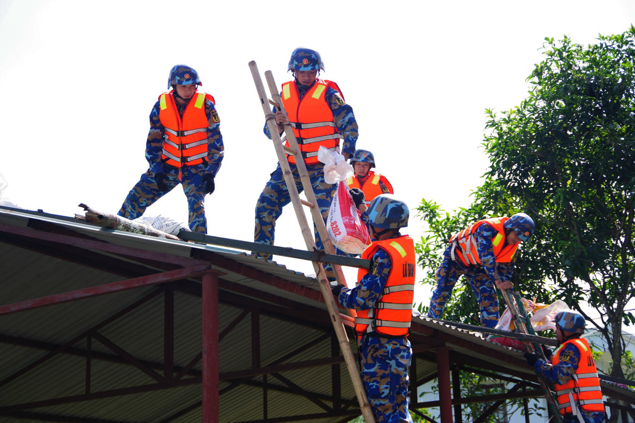 Cán bộ, chiến sỹ Vùng 1 Hải quân giúp người dân chống bão.
(Ảnh: Báo HQVN)