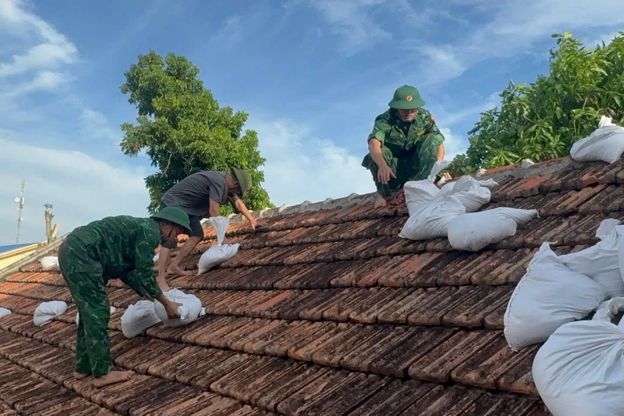 Cán bộ, chiến sĩ Đồn Biên phòng Cát Hải giúp người dân gia cố nhà cửa.