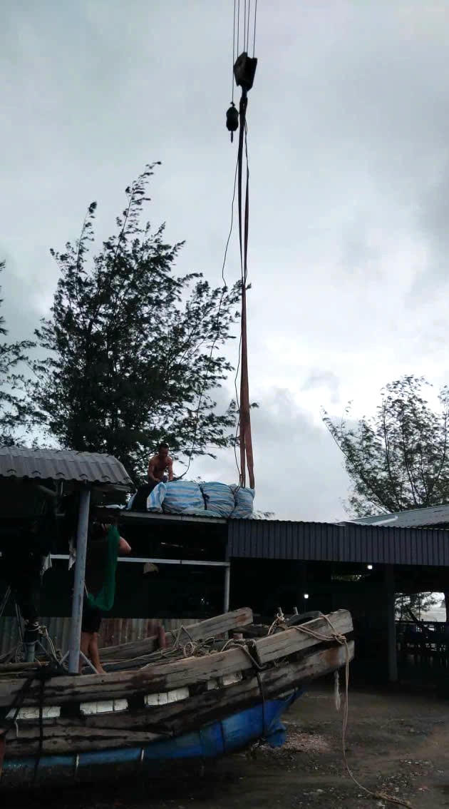 Hình ảnh ngư dân cẩu thuyền chở mồi cung cấp cho cá ăn.