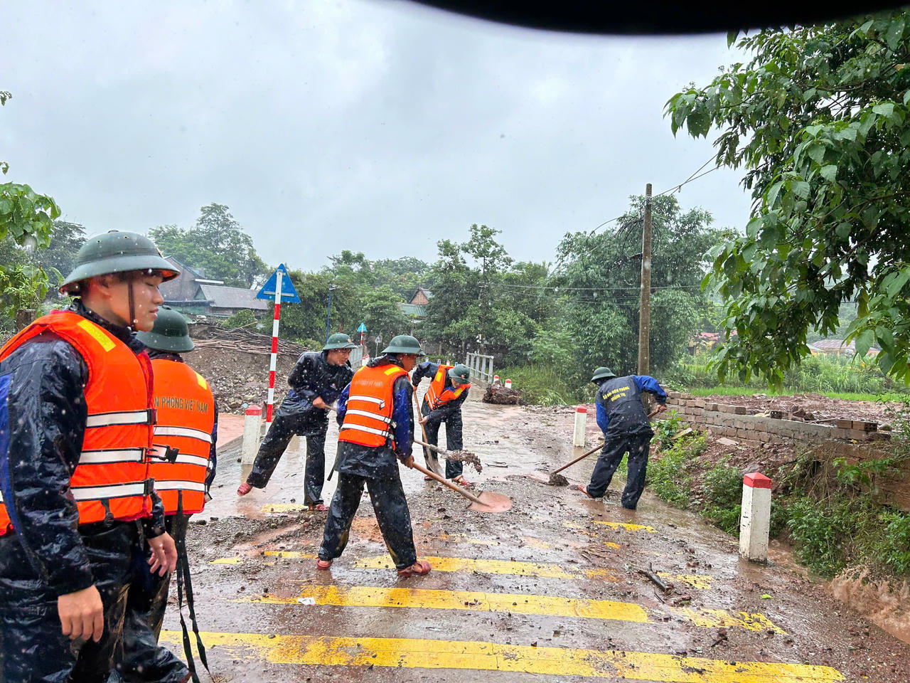 Biên phòng phối hợp cùng người
dân khẩn trương thu dọn hiện trường trên tuyến đường bị sạt lở.