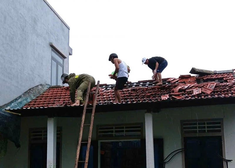 Công an xã Quảng Điền giúp dân lợp lại mái nhà.