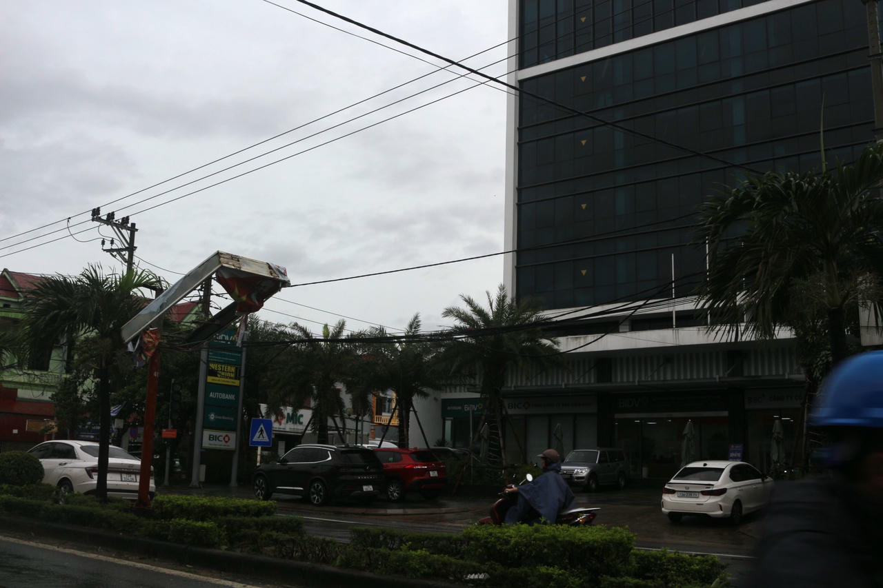 Biển quảng cáo bị bão cuốn treo lơ lửng.