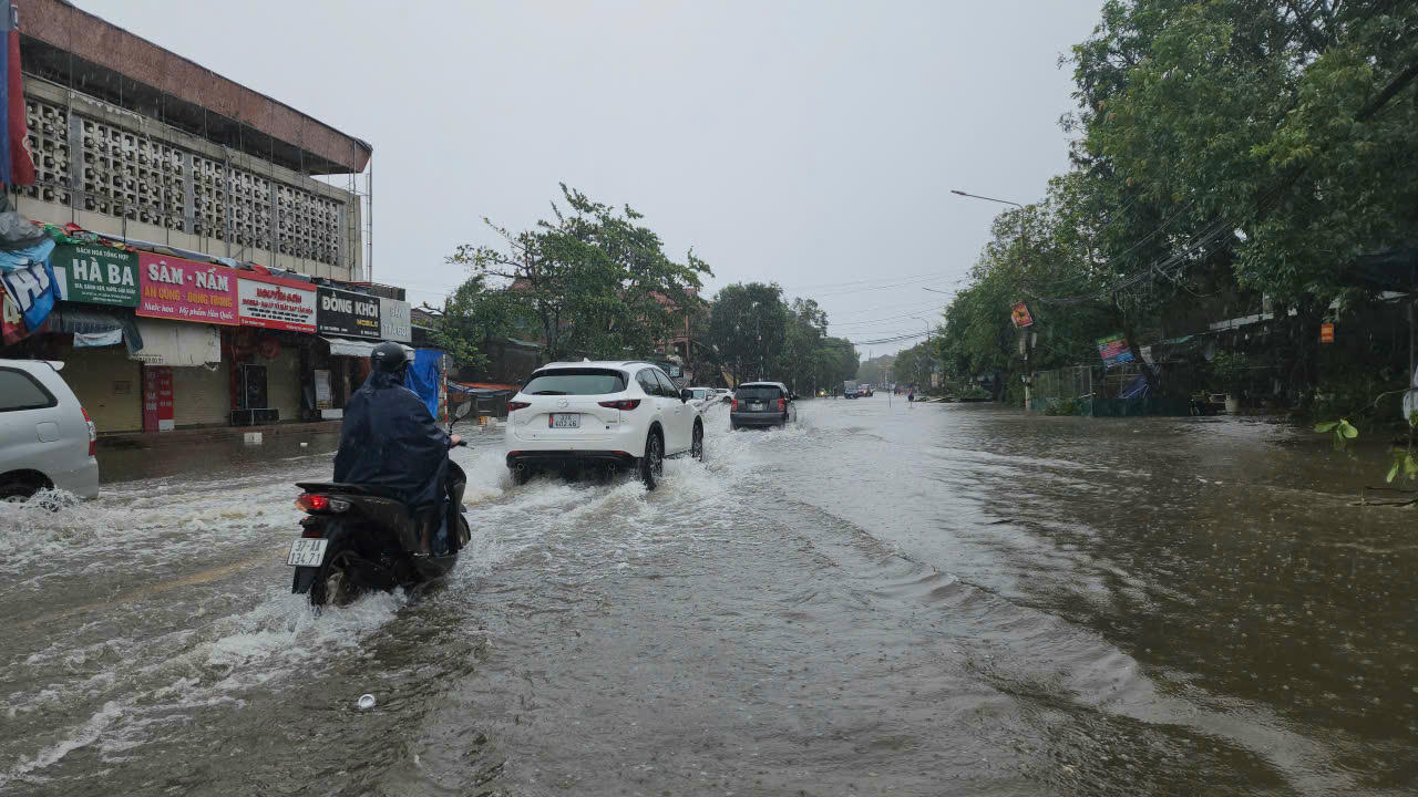 Nước tại khu vực chợ Ga Vinh ngập khiến xe cộ đi lại khó khăn.