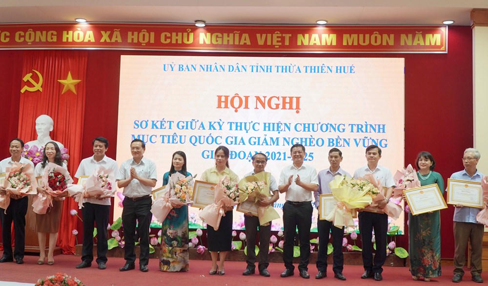 Ông Bình (thứ 5 bên phải qua) trao Bằng khen cho tập thể có thành tích tiêu biểu trong phong trào thi đua “Vì người nghèo giai đoạn 2021 - 2025”.