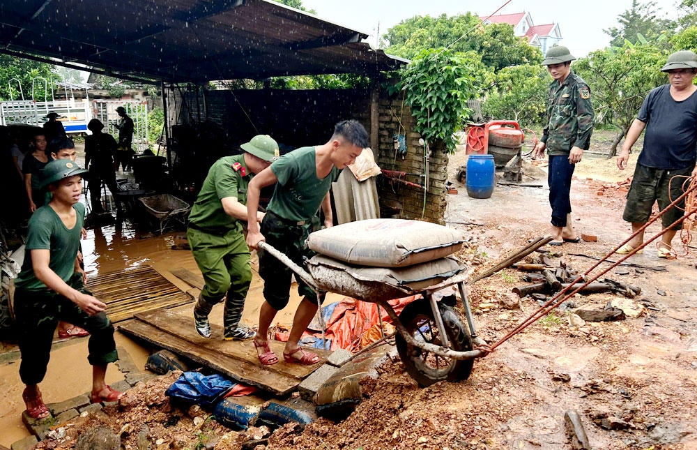 Cán bộ, chiến sĩ Trung đoàn 101, Sư đoàn 325 (Quân đoàn 12) cùng Công an xã Nam Dương  (Bắc Ninh) khẩn trương giúp người dân di chuyển tài sản do mưa lũ.