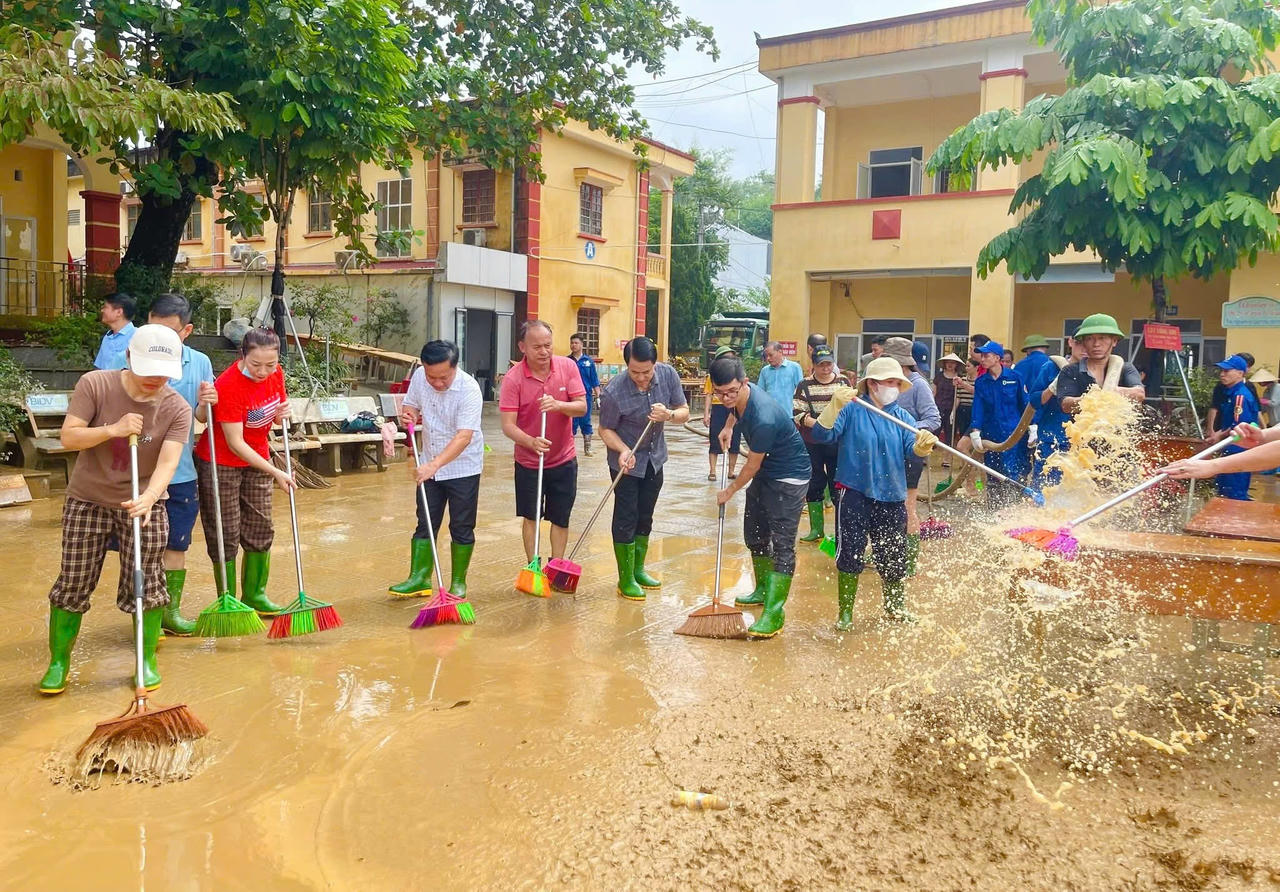 Dưới lớp bùn đất dày đặc phủ kín
đường phố, cán bộ, công nhân viên nhà máy đã không quản ngại khó khăn, cùng người
dân địa phương dọn dẹp, thu gom rác, bùn đất và khơi thông dòng chảy. 