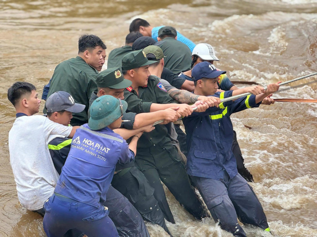 Lực lượng chức năng tỉnh Tuyên Quang và người dân hỗ trợ xe bị gặp nạn trong lũ. (Ảnh: PV)