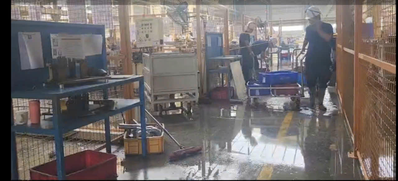 Công
nhân thu dọn, múc nước mưa trong xưởng sản xuất.

 