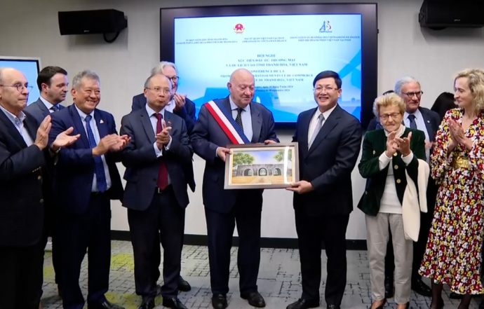 Ông Mai Xuân Liêm - Phó chủ tịch UBND tỉnh Thanh Hóa trao quà lưu niệm cho các nhà đầu tư tại chương trình xúc tiến đầu tư của tỉnh. 