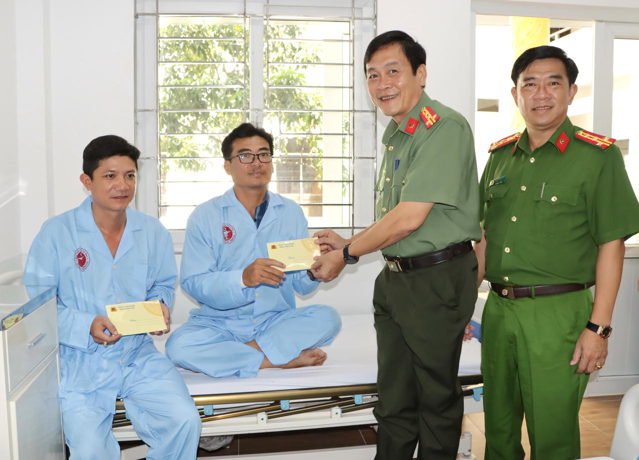 Đại tá Hồ Việt Triều – Giám đốc Công an tỉnh và Đại tá Châu Quốc Huy – Phó Giám đốc, Thủ trưởng Cơ quan Cảnh sát điều tra Công an tỉnh, trao quà động viên hai cán bộ bị thương trong quá trình khống chế, bắt giữ đối tượng.