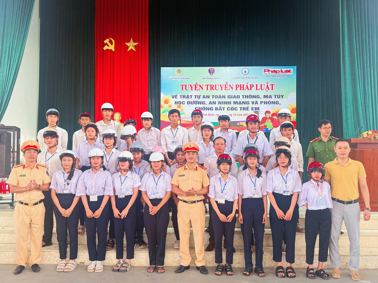 Tặng mũ bảo hiểm cho các em học sinh.