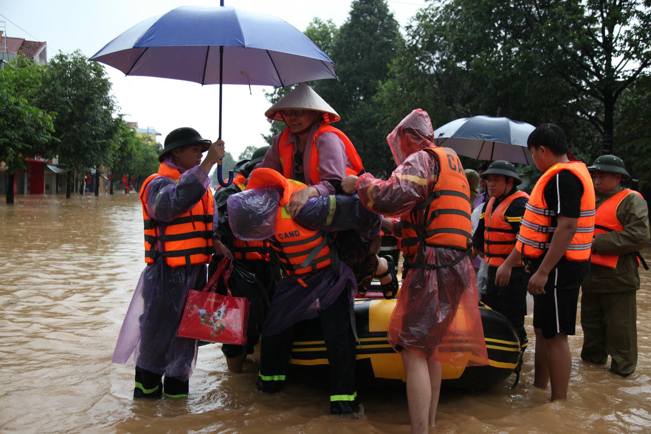 Lực lượng Công an hỗ trợ di chuyển người dân ra khỏi khu vực ngập lụt tại khu vực cầu Mỏ Bạch.