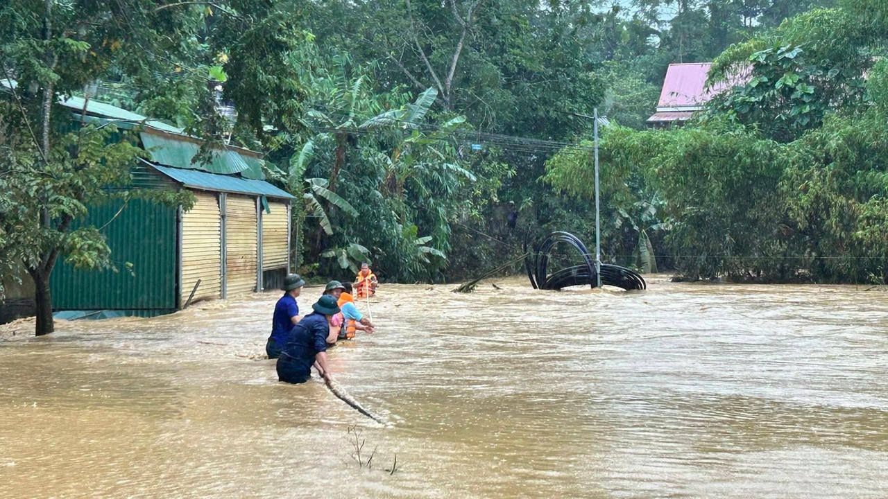 Lực lượng chức năng xã Lực Hành giải cứu 2 ông cháu mắc kẹt giữa lũ. Ảnh: CTV