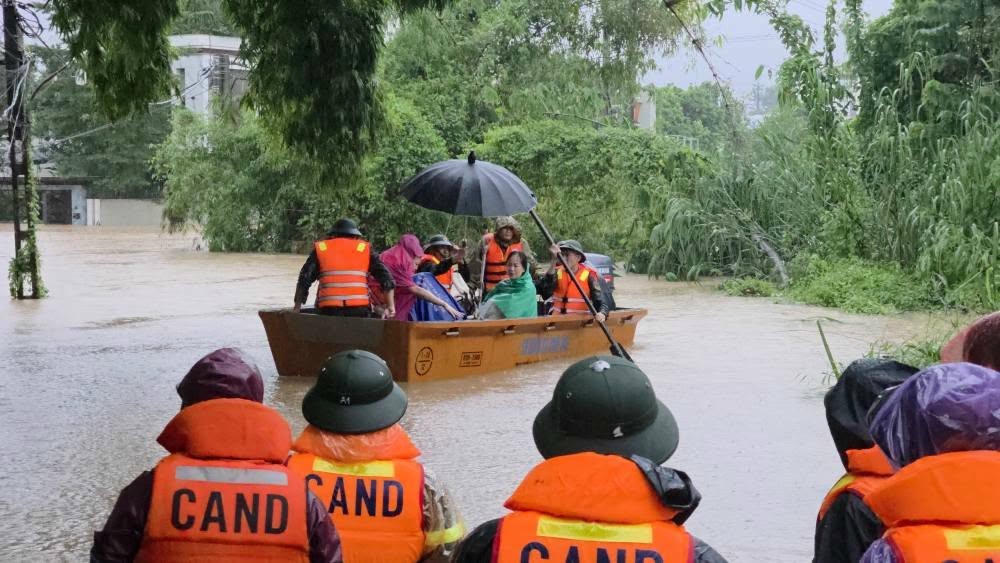 Lực lượng Công an hỗ trợ người dân thoát khỏi vùng ngập sâu.