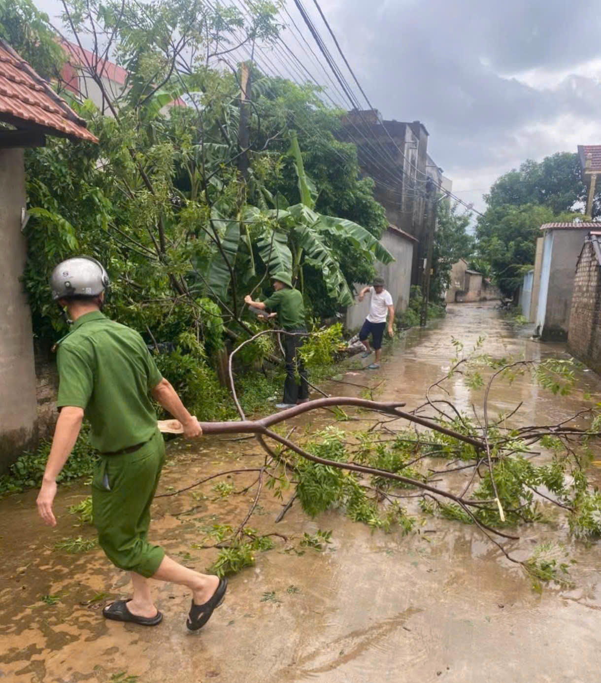 Lực lượng Công an giúp thu dọn cành cây đổ gãy, bảo đảm an toàn giao thông.