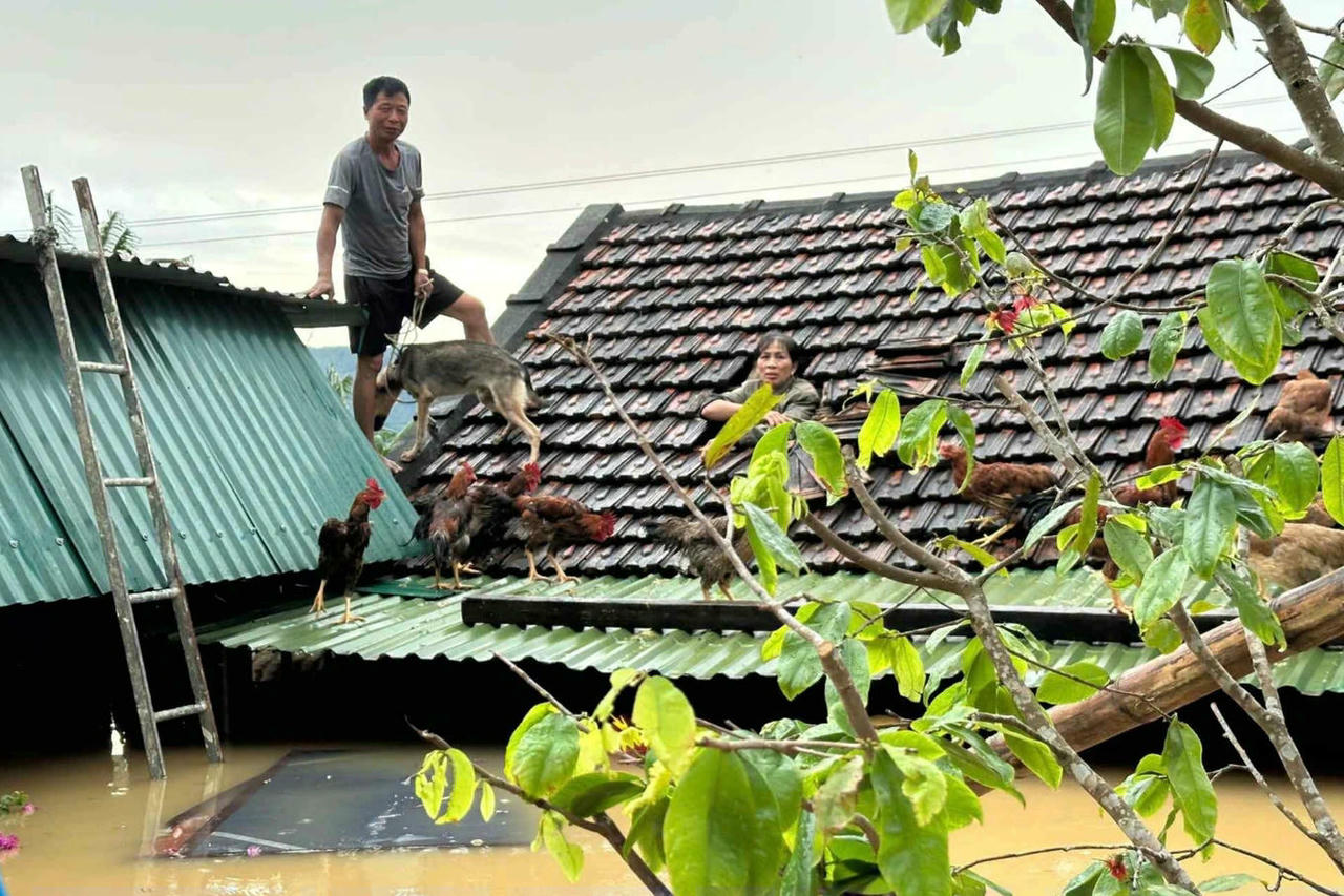 Người dân xóm Diễn Nam, xã Tân Kỳ (tỉnh Nghệ An) leo lên nóc nhà tránh lũ. (Ảnh: Nguyễn Sơn/Dân trí)