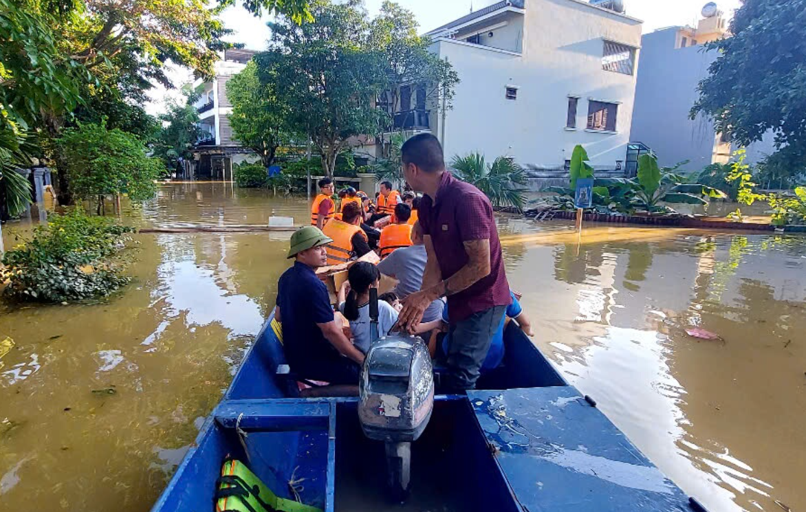 Các thành viên cứu hộ hỗ trợ người dân sơ tán khỏi vùng lũ an toàn. (Ảnh: UBND xã Hương Sơn cung cấp)