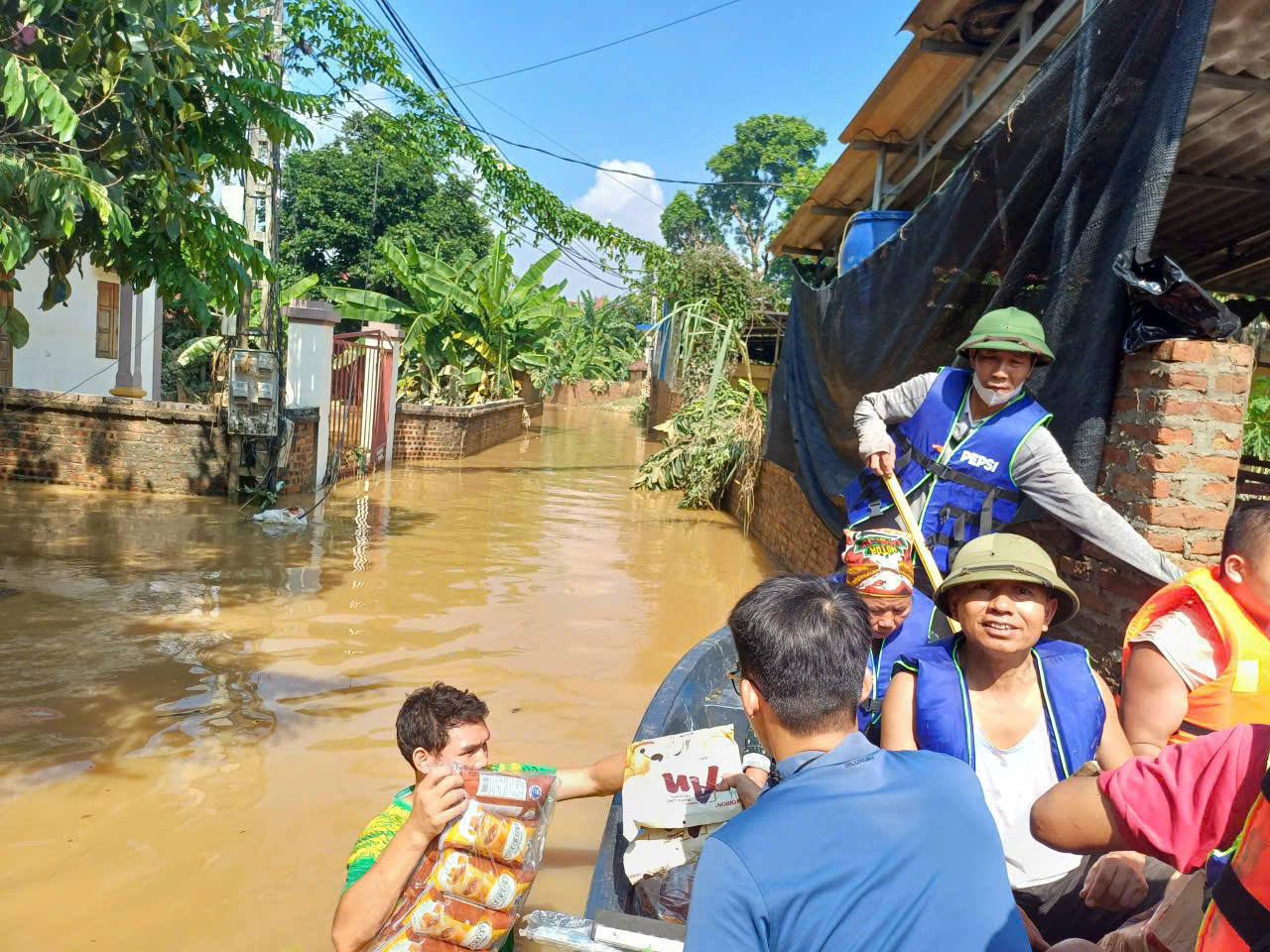 Đoàn thiện nguyện trao lương thực cho người dân bị ngập sâu.