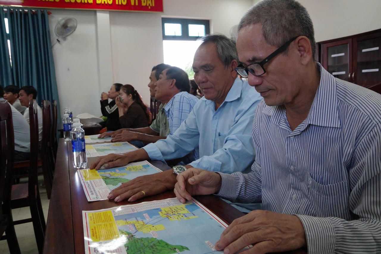 Ngư dân xã Bình Châu tìm hiểu các đường ống dẫn khí biển trên tờ rơi.