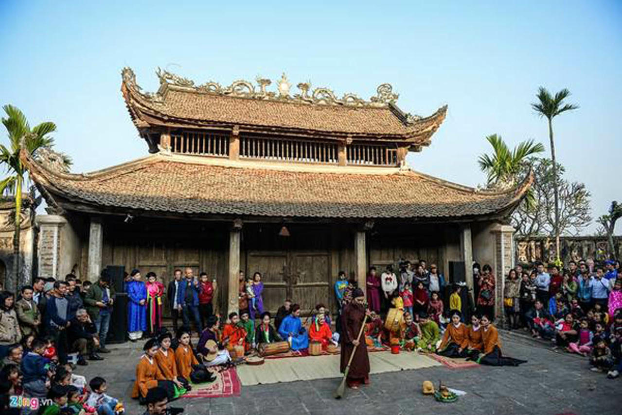 Không gian Tết xưa tại đình làng So (Hà Nội), với các nghi lễ dựng cây nêu, dâng lễ, gói và luộc bánh chưng, viết thư pháp, hát cửa đình… (Nguồn: Zing)