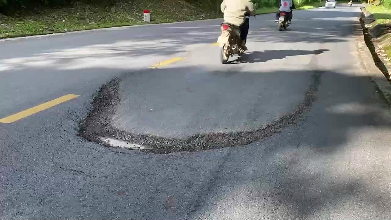 Các vết rạn nứt dài cắt ngang đường gây tiềm ẩn nguy cơ mất an toàn giao thông.