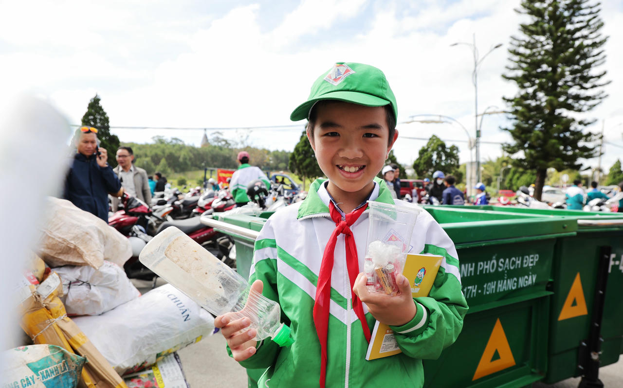 Một em học sinh vui mừng khi đổi rác lấy quà.