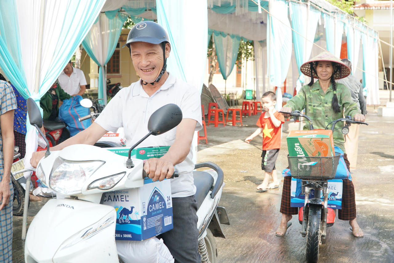 Người dân phấn khởi nhận quà từ đoàn công tác.