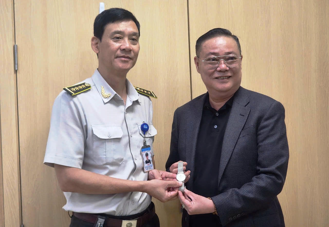 Ông Nguyễn Hồng Sơn - Đội trưởng an ninh soi chiếu quốc nội (sân bay Đà Nẵng) trao trả chiếc đồng hồ, món kỷ vật mang giá trị tinh thần đặc biệt cho hành khách Nguyễn Văn Tuấn.