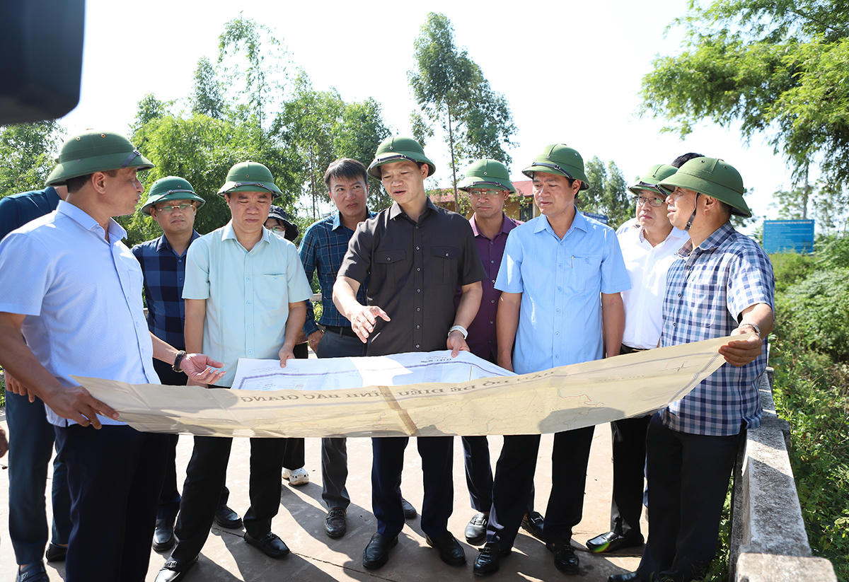 Chủ tịch UBND tỉnh Bắc Ninh và đoàn công tác xem sơ đồ hệ thống thủy lợi trên địa bàn xã Mỹ Thái.