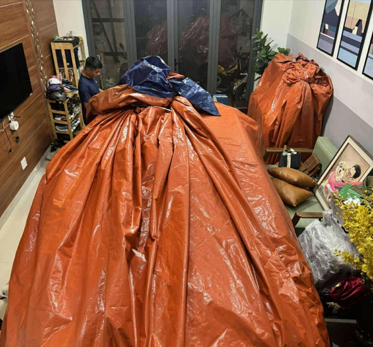 Anh Nguyên gói kín chiếc BMW bằng bạt xanh cam để chống lụt giữa mưa lớn ở Đà Nẵng.